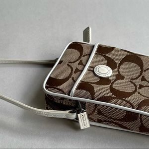 Brown Coach wristlet with white leather trim